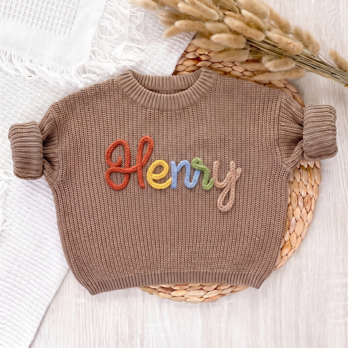 Khaki personalized sweater with hand embroidered multicolor yarn name Henry, laid flat