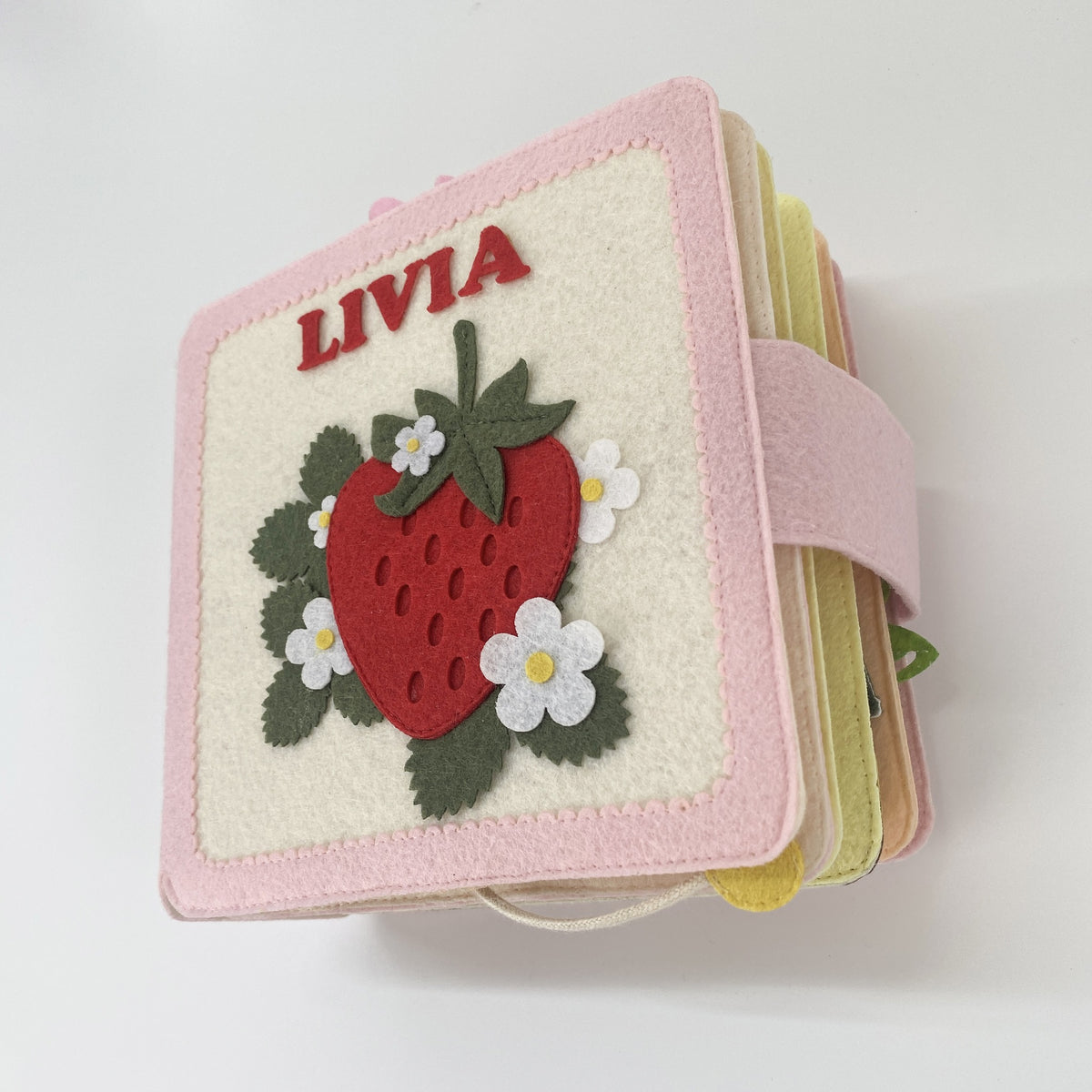 Personalized strawberry felt quiet book with name Livia, side view of the felt pages
