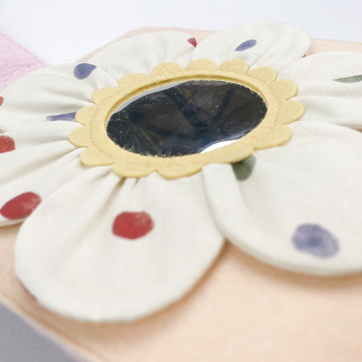 Felt flower page with a hidden baby-safe mirror in a strawberry quiet book