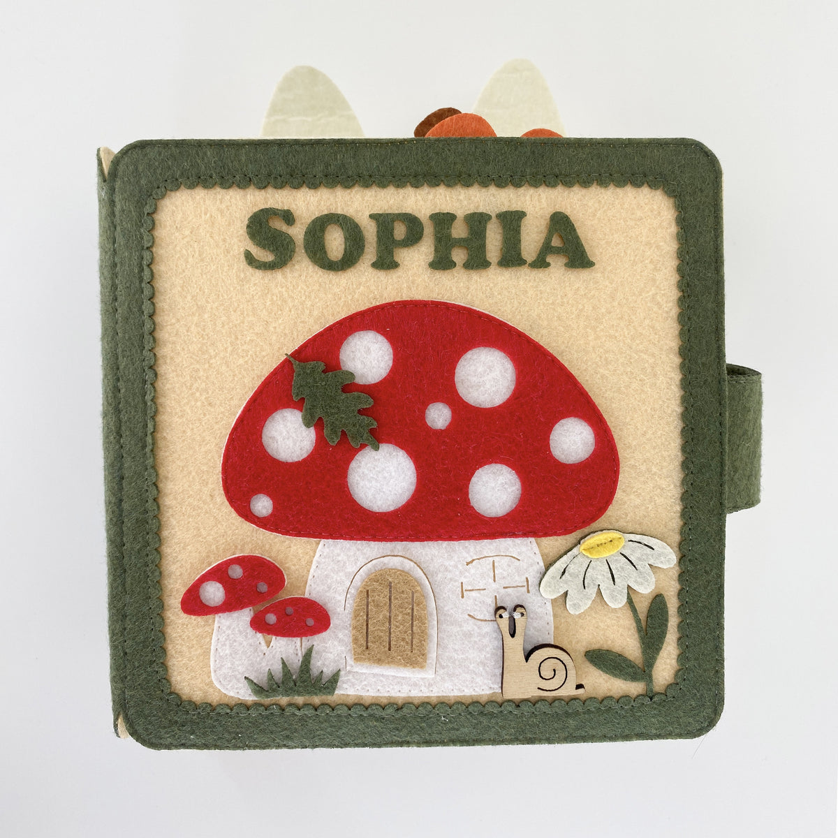 Front view of a personalized mushroom fairy garden felt busy book with embroidered name Sophia