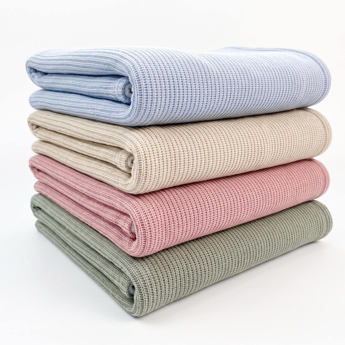 Stack of four sherpa baby blankets in blue, beige, pink and sage