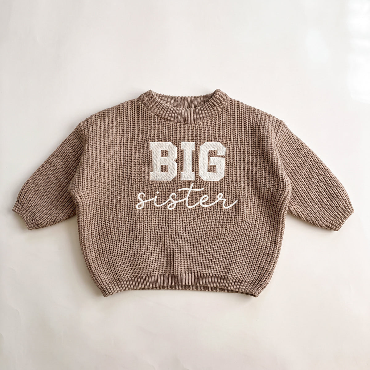 Khaki chunky knit baby sweater with BIG sister embroidery, laid flat