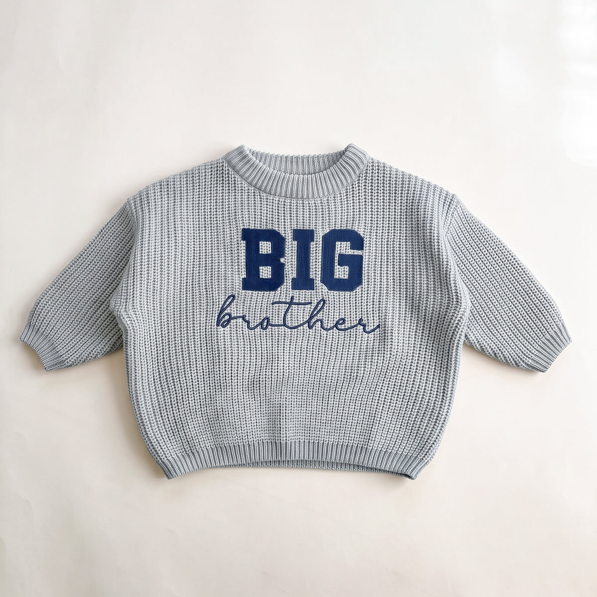 Sky Grey chunky knit baby sweater with BIG brother embroidery, laid flat