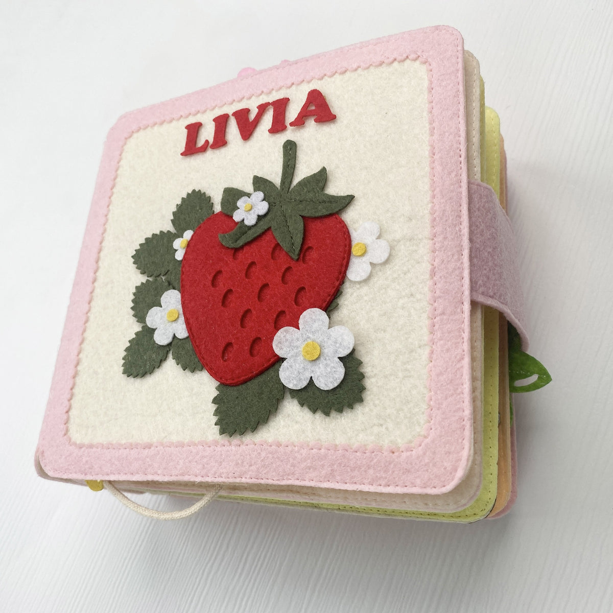 Personalized strawberry felt busy book with embroidered name Livia on the cover